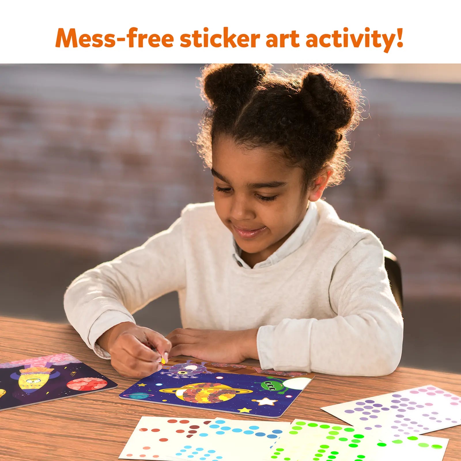 Child creating outer space sticker art from Dot it! Outer Space no mess sticker kit