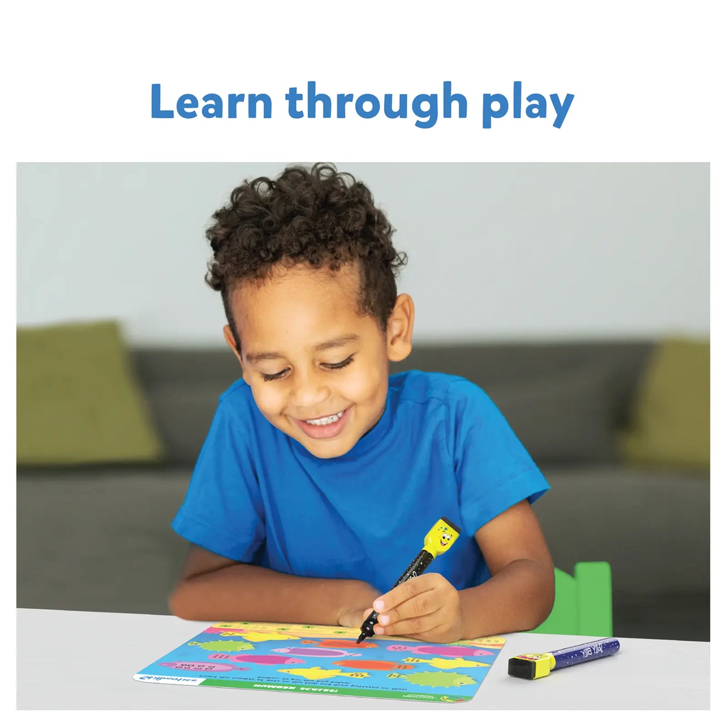 Smiling boy drawing on a colorful map with I Can Write & Preschool Champion educational product