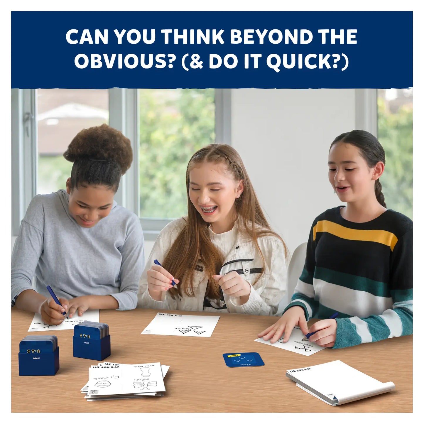 Three girls playing a drawing game from It’s Not It fast-paced creative game for ages 7+