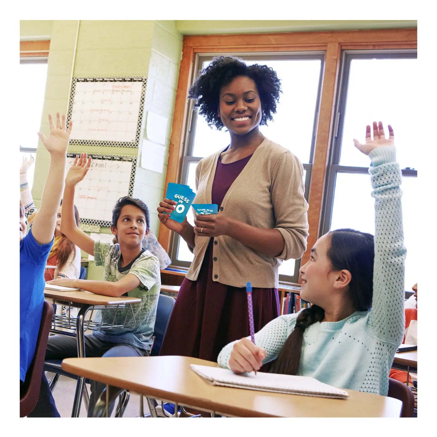 Teacher holding blue game cards for Guess in 10 US History educational game