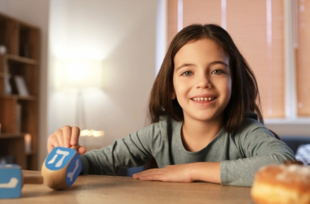 A girl holding dreidel in her hand