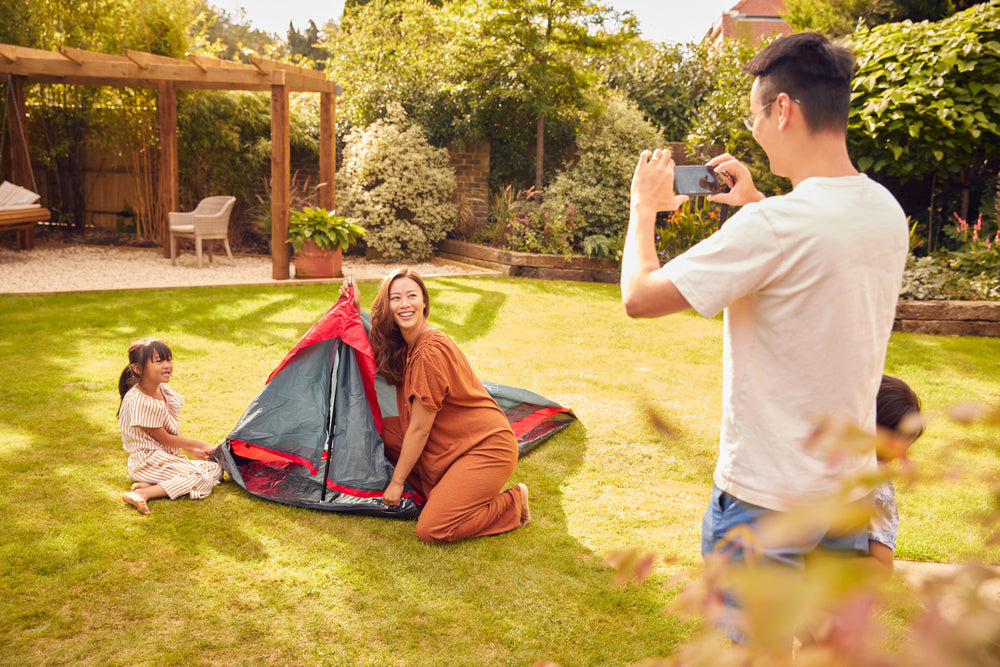 family setting up summer camp in the backyard