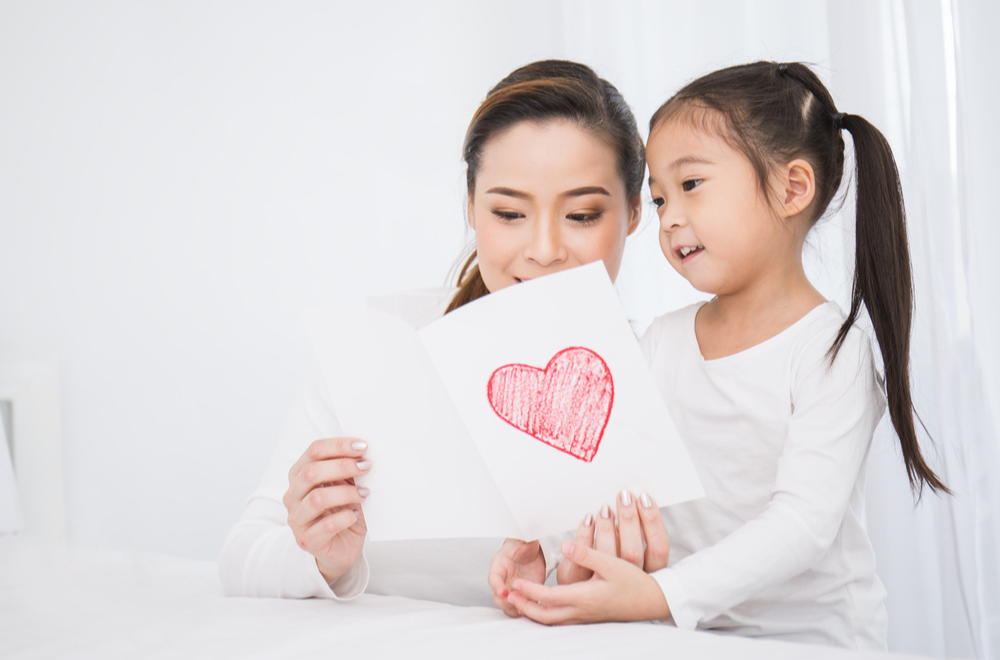 Mom and daughter doing valentine's crafts together greeting card 