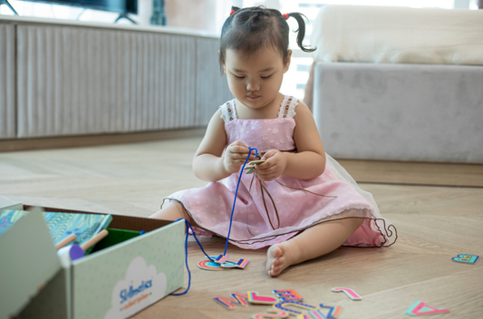 Baby girl playing with skillmatics subscription box