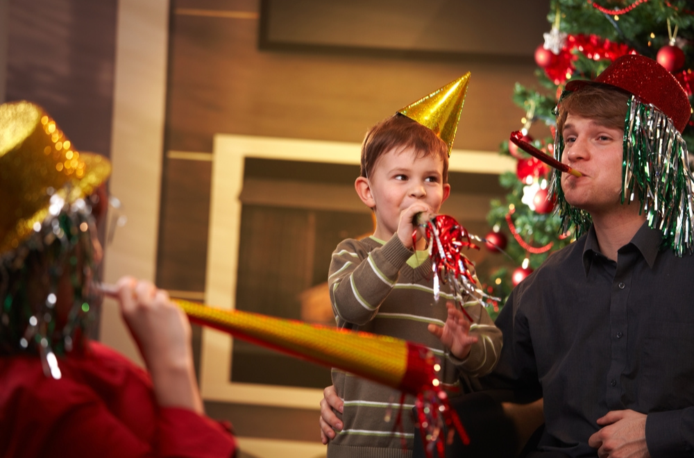 Child celebrating new year's eve with family and smiling