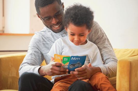 Boy and father looking at toddler flash cards and smiling