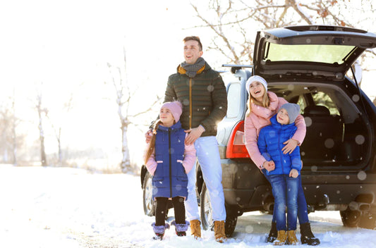 Family standing in front of a car smiling