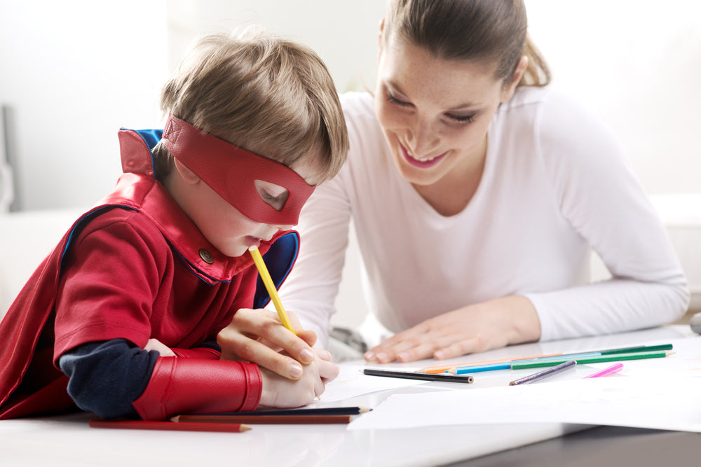 A mother and child doing superhero themed worksheets 