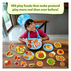 Child wearing a chef’s hat playing with realistic play food set for pretend cooking