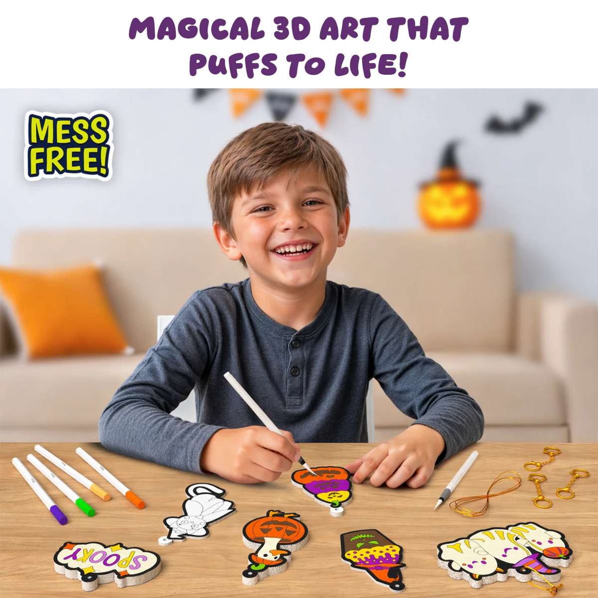 Smiling boy at a wooden table in a Halloween-decorated room coloring a stacked pumpkin Aqua Puff with a white marker, surrounded by colored markers, a water pen, gold keychains, string and puffed foam shapes including a Spooky sign, bat, goose and ghost cat. Text: Magical 3D art that puffs to life.