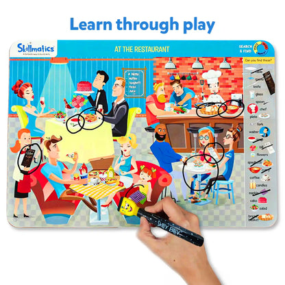Skillmatics educational game board with cartoon characters at a restaurant, featuring a hand holding a marker.