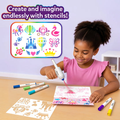 A smiling child in a pink top uses a white Skillmatics spraybrush on a stencil sheet at a wooden table. Colorful markers and extra stencil sheets lie nearby; a rainbow-bordered panel displays unicorn, hot-air balloon, carriage, swan, diamonds, castle, butterfly, rose, winged heart and crown designs.
