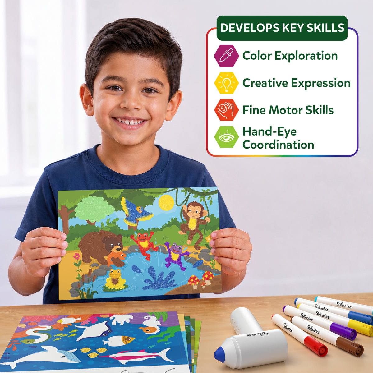 A smiling boy holds a completed jungle animal scene created with Skillmatics Spraybrush Art. The panel highlights four developmental benefits: colour exploration, creative expression, fine motor skills, and hand-eye coordination. Colourful markers, spraybrush equipment, and picture boards are displayed on the table.