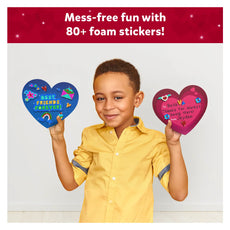 Boy holding decorated heart-shaped crafts from Foil Fun Friendship Hearts Art Kit
